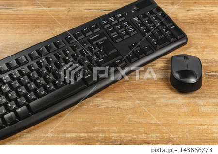Office desk setup with keyboard and mouse on wooden surface Office desk setup with keyboard and mouse on wooden surface 143666773
