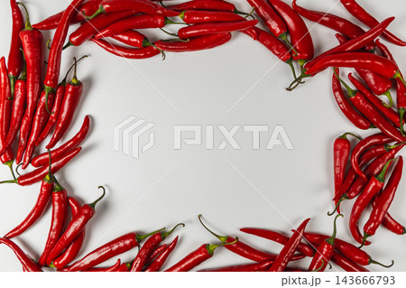 Red chili peppers arranged around a white background Red chili peppers arranged around a white background 143666793