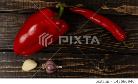 Pepper, chili, onion, and garlic on a wooden surface Pepper, chili, onion, and garlic on a wooden surface 143666946