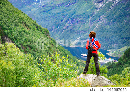 Tourist over Geirangerfjord with norwegian flag 143667053