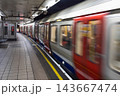 Subway train moving along a curved underground station platform 143667474