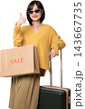 Happy asian woman wearing sunglasses holding paper bag and luggage showing thumbs up gesture while shopping for smart travel artificial intelligence 143667735