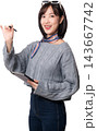 Happy young asian woman holding stylus and digital tablet while working on artificial intelligence concept on isolated white studio background with smiling expression 143667742