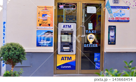 Cefalu, Italy. 21 August 2026. Urban landscape. Sign with the inscription: ATM Euronet. Cefalu, Italy. 21 August 2026. Urban landscape. Sign with the inscription: ATM Euronet. 143668454