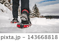 Person Hiking on Snowy Mountain Trail in Snowshoes 143668818