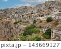 Matera ancient cave dwellings overlooking rugged ravine 143669127