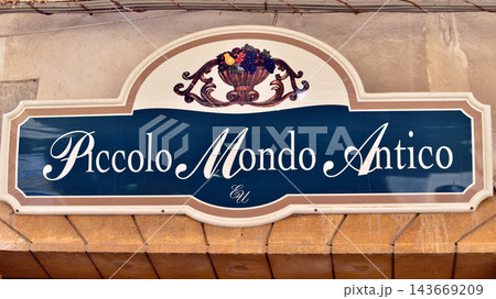 Cefalu, Italy. 20 August 2026. Urban landscape. Neon sign with the inscription: Piccolo Mondo Antico. Cefalu, Italy. 20 August 2026. Urban landscape. Neon sign with the inscription: Piccolo Mondo Antico. 143669209