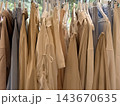 Neutral beige clothing garments hanging closely together on a retail rack with soft natural background Neutral beige clothing garments hanging closely together on a retail rack with soft natural background 143670635