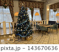 Decorated Christmas tree in elegant restaurant dining room with festive ornaments and warm lighting Decorated Christmas tree in elegant restaurant dining room with festive ornaments and warm lighting 143670636