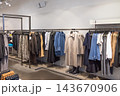 Womenswear garments hanging on metal rails in a fashion shop 143670906