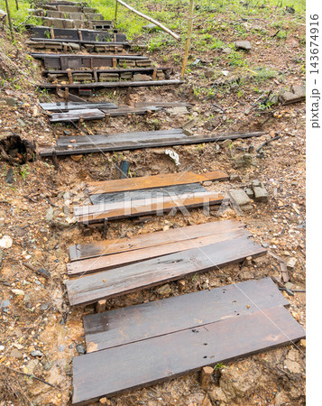 Rustic wooden staircase built on muddy hill in tropical nature 143674916