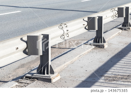 Closeup view of a metal guardrail and support posts Closeup view of a metal guardrail and support posts 143675385