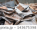 Heap of rusted metal sheets and scrap panels stacked outdoors 143675398