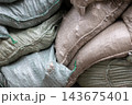 Stacked sandbags with worn woven texture used for flood protection 143675401