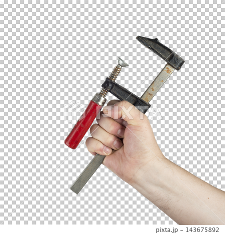 A hand holds a C-clamp with a red handle. A hand holds a C-clamp with a red handle. 143675892