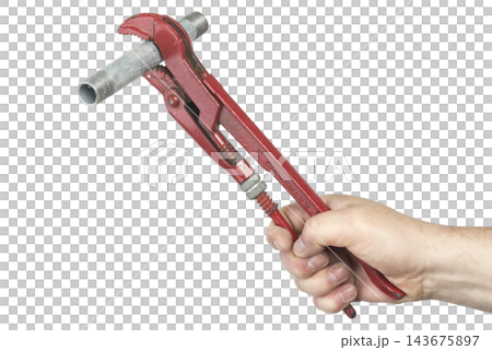 A hand holds a red pipe wrench gripping a metal pipe A hand holds a red pipe wrench gripping a metal pipe 143675897