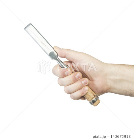 A hand holds a well-used metal putty knife with a wooden handle. A hand holds a well-used metal putty knife with a wooden handle. 143675918