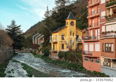 Yellow tower house beside Freser river with forested mountain in Ribes de Fresser 143676062