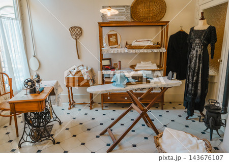 Period laundry and sewing room with sewing machine, ironing board and dress on a mannequin at Casa Mila 143676107