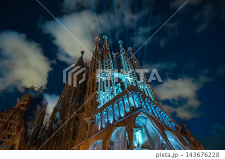Passion facade of Sagrada Familia lit at dusk under a deep blue cloudy sky 143676228