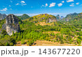 Dramatic Limestone Peaks Over Verdant Countryside in Laos Dramatic Limestone Peaks Over Verdant Countryside in Laos 143677220
