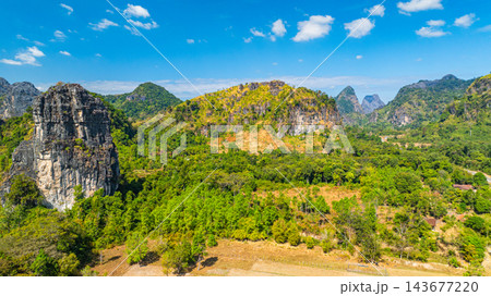 Dramatic Limestone Peaks Over Verdant Countryside in Laos 143677220
