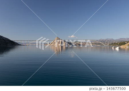 Krka Bridge Arch Bridge Structure Over Calm Blue Water with Clear Sky Krka Bridge Arch Bridge Structure Over Calm Blue Water with Clear Sky 143677500