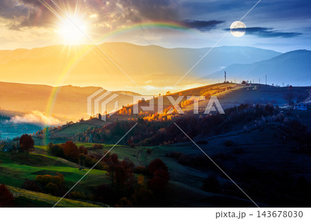 mountainous countryside landscape. day meet night. sun and moon on epic sky above the distant valley. colorful fields and trees on the hill. beautiful nature landscape of Carpathians 143678030