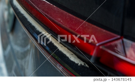 Close up of dust coated red car tail light and rear trim after travel on an unpaved road, automotive exterior detail 143678145