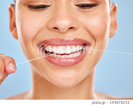 Dental floss, woman and wellness in studio for healthy gums, teeth whitening or morning routine on blue background. Closeup, oral care and model for fresh breath, remove plaque or mouth hygiene Dental floss, woman and wellness in studio for healthy gums, teeth whitening or morning routine on blue background. Closeup, oral care and model for fresh breath, remove plaque or mouth hygiene 143678252