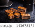 Close-Up Stack Of Chewy Chocolate Brownies With Crumbly Texture On Dark Surface 143678374