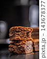 Close-Up Stack Of Chewy Chocolate Brownies With Crumbly Texture On Dark Surface 143678377