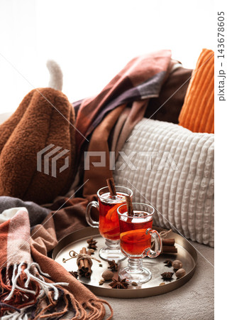 Cozy autumn setup with hot spiced tea and cinnamon on tray Cozy autumn setup with hot spiced tea and cinnamon on tray 143678605