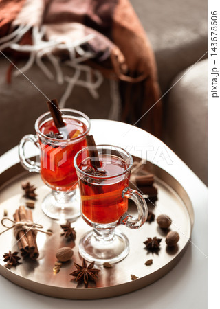 Two glass mugs of hot mulled wine with cinnamon and anise on tray Two glass mugs of hot mulled wine with cinnamon and anise on tray 143678606