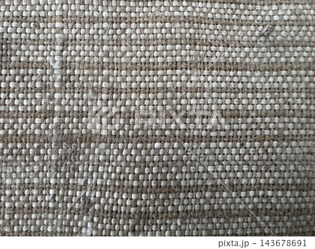 Close-up of coarse woven fabric texture with beige twisted brown threads and white weft yarns in a tight checkered pattern Close-up of coarse woven fabric texture with beige twisted brown threads and white weft yarns in a tight checkered pattern 143678691