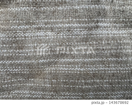 Rough woven textile close-up with tan fibrous yarns and thin white horizontal stripes, full frame natural-look fabric background Rough woven textile close-up with tan fibrous yarns and thin white horizontal stripes, full frame natural-look fabric background 143678692