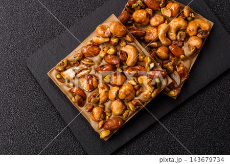 A bar of sugar free white chocolate with pistachios, almonds, and hazelnuts. A white chocolate bar A bar of sugar free white chocolate with pistachios, almonds, and hazelnuts. A white chocolate bar 143679734