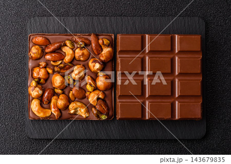 A bar of sugar free milk chocolate with pistachios, almonds, and hazelnuts. A milk chocolate bar 143679835