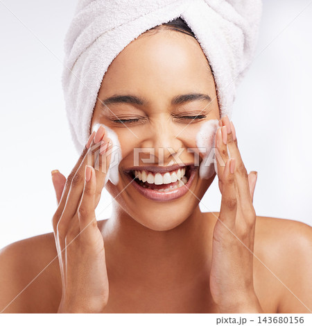 Foam wash, hands and woman in studio with skincare for cosmetics, natural glow or shine treatment on white background. Towel, body and model cleaning face for wellness, dermatology or morning routine 143680156