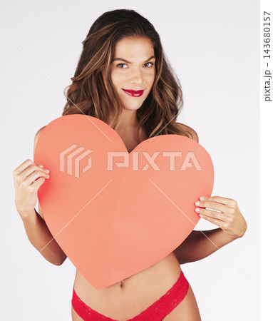 Portrait, woman and love heart with lingerie in studio for anniversary, romance and valentines day. Red lipstick, model girl and underwear with emoji by white background for celebration and happiness 143680157