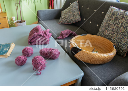 Pink Yarns and Knitted Pieces on a Table at Home Pink Yarns and Knitted Pieces on a Table at Home 143680791