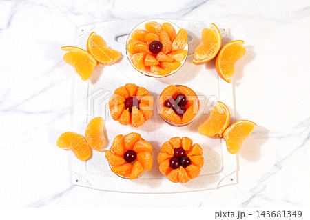 Fun butterflies and flowers made from mandarin oranges, with cherry eyes. A playful treat for children and a creative serving idea for parties and birthdays. A fun option for a cafe menu Fun butterflies and flowers made from mandarin oranges, with cherry eyes. A playful treat for children and a creative serving idea for parties and birthdays. A fun option for a cafe menu 143681349
