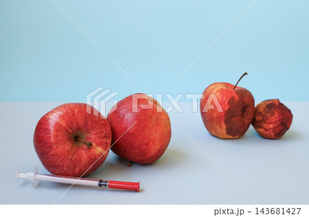 Two fresh young apples beside syringe and two old wrinkled rotten apples on light blue background, copy space. Concept of anti-aging, cosmetology injections, rejuvenation, youth and aging Two fresh young apples beside syringe and two old wrinkled rotten apples on light blue background, copy space. Concept of anti-aging, cosmetology injections, rejuvenation, youth and aging 143681427