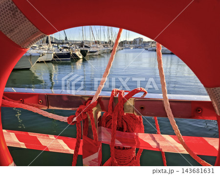 View of Marina and Yachts Framed Through Red Lifebuoy View of Marina and Yachts Framed Through Red Lifebuoy 143681631