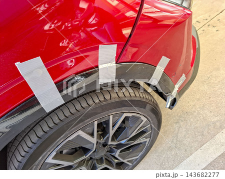 Damaged Red Car Fender Repaired Temporarily With Duct Tape 143682277