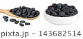 black raisins in wooden spoon isolated on white background 143682514