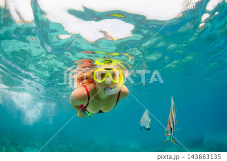 Happy family - active woman in snorkeling mask dive underwater, see tropical fishes in coral reef sea pool. Travel adventure, swimming activity and watersports on summer beach vacation with child. Happy family - active woman in snorkeling mask dive underwater, see tropical fishes in coral reef sea pool. Travel adventure, swimming activity and watersports on summer beach vacation with child. 143683135