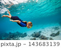 Happy family - active girl in snorkeling mask dive underwater, see tropical fishes in coral reef sea pool. Travel adventure, swimming activity and watersports on summer beach vacation with kids. 143683139