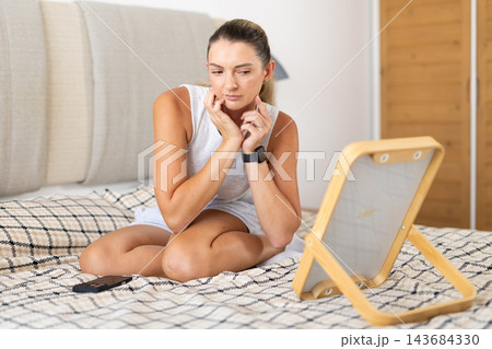 In bedroom girl looking at her reflection in mirror 143684330