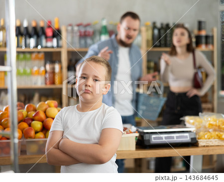 Couple man and woman quarreling with boy in grocery store Couple man and woman quarreling with boy in grocery store 143684645